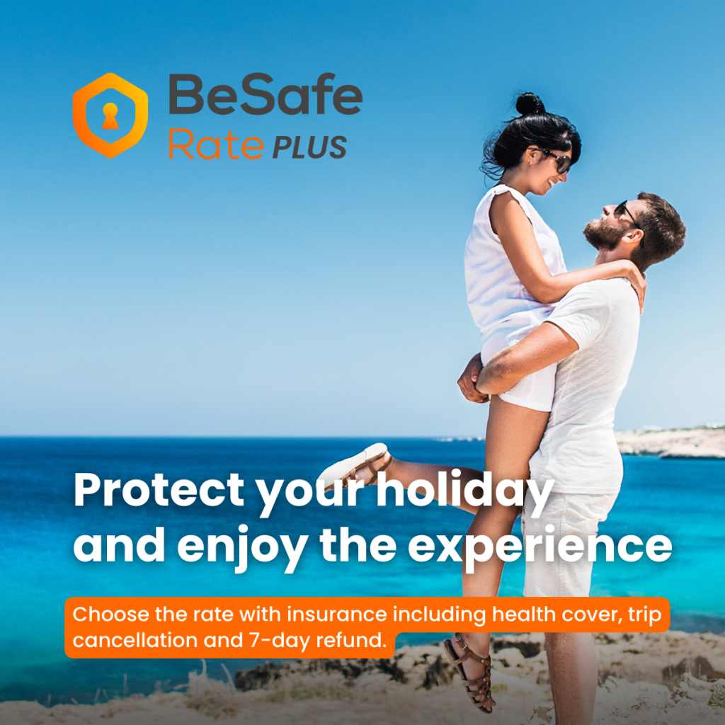 Logotipo de BeSafe Rate PLUS sobre un fondo de cielo azul con una pareja abrazándose en una playa soleada, vistiendo ropa blanca y gafas de sol, con el horizonte y el océano visibles.