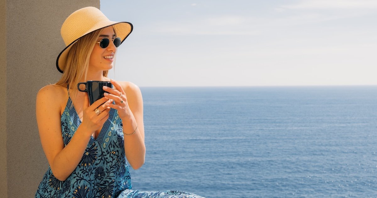 Una mujer sonriente mirando hacia el hermoso mar frente a las Cinque Terre