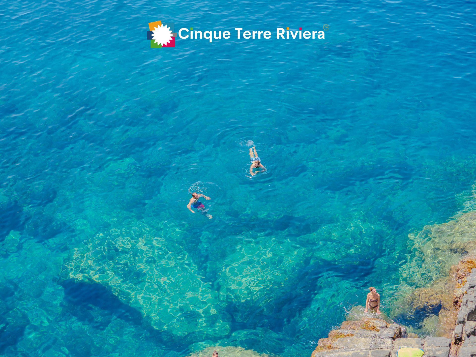 Agua turquesa cristalina sobre las rocas en un lugar para nadar en Riomaggiore, en las Cinque Terre