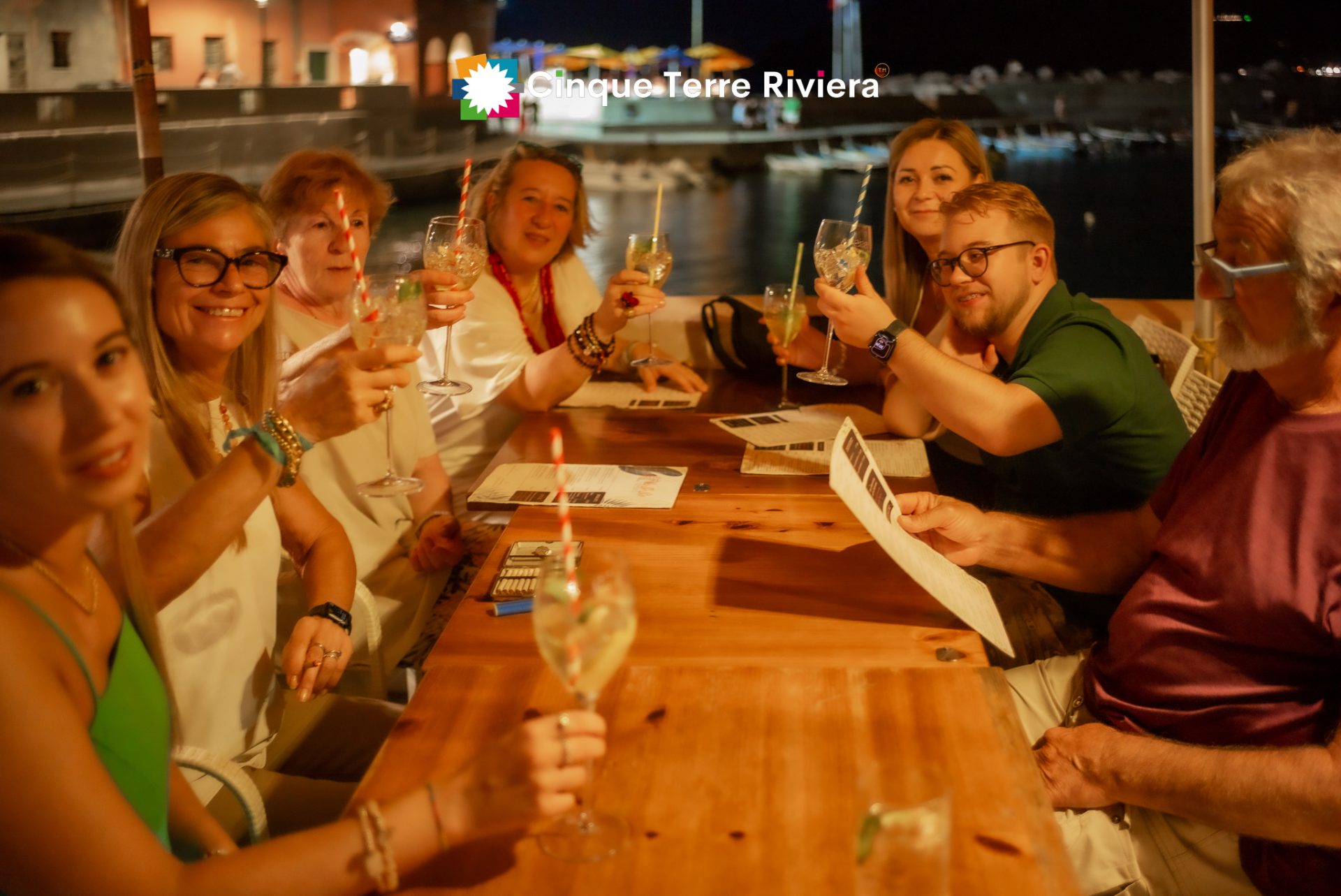 friends toasting at sunset aperitif in the piazza of Vernazza